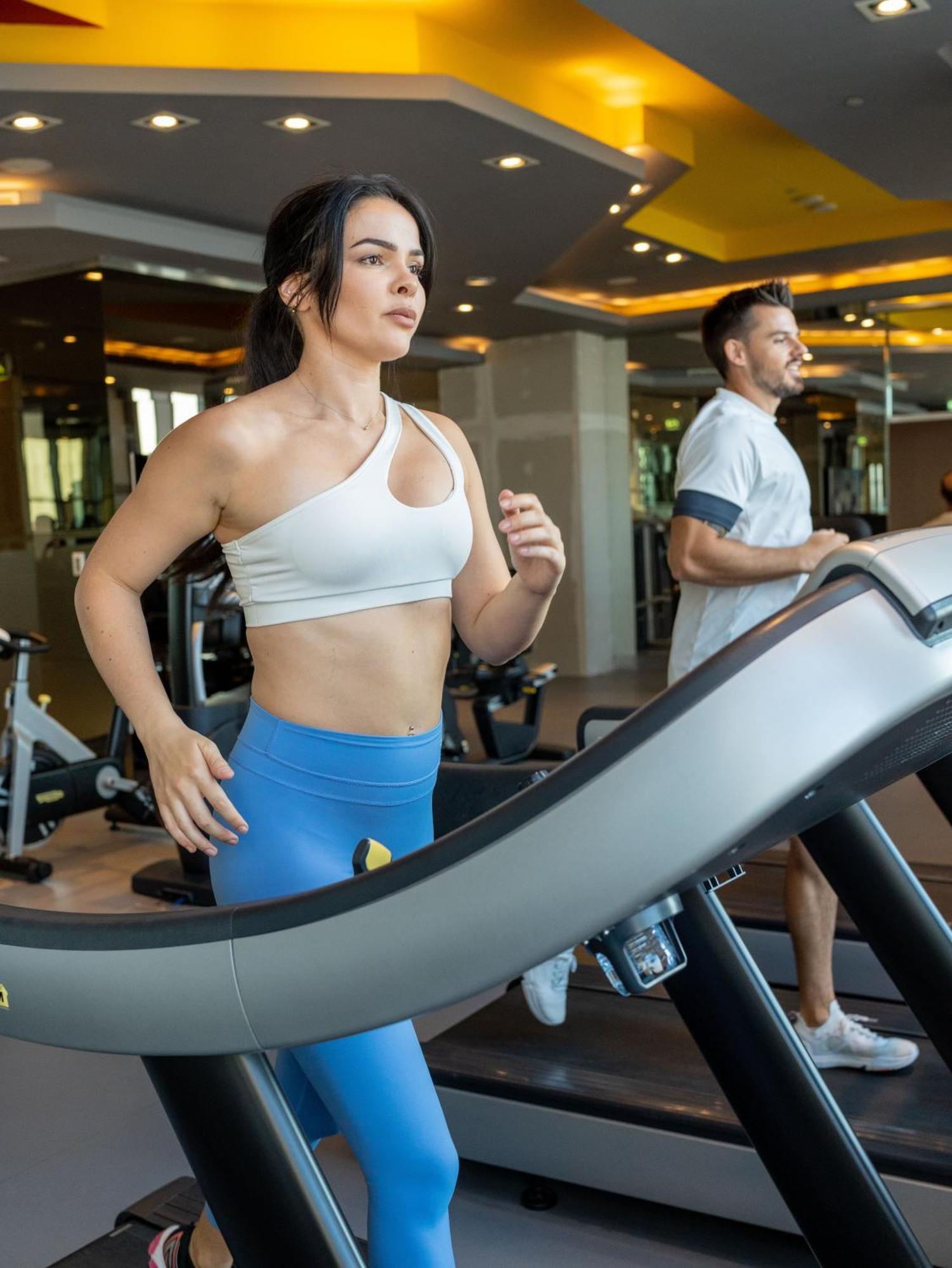 V Hotel Dubai, Curio Collection By Hilton Екстер'єр фото A woman and a man on a treadmill